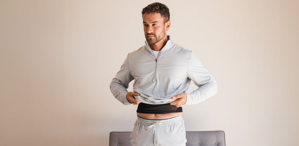 Infraway founder Max Betkowski lifting his shirt to show the L1 far infrared wearable worn against his lower back