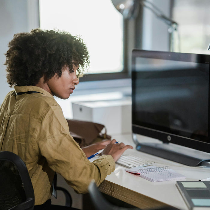 Person sitting at a desk using a computer in an office setting